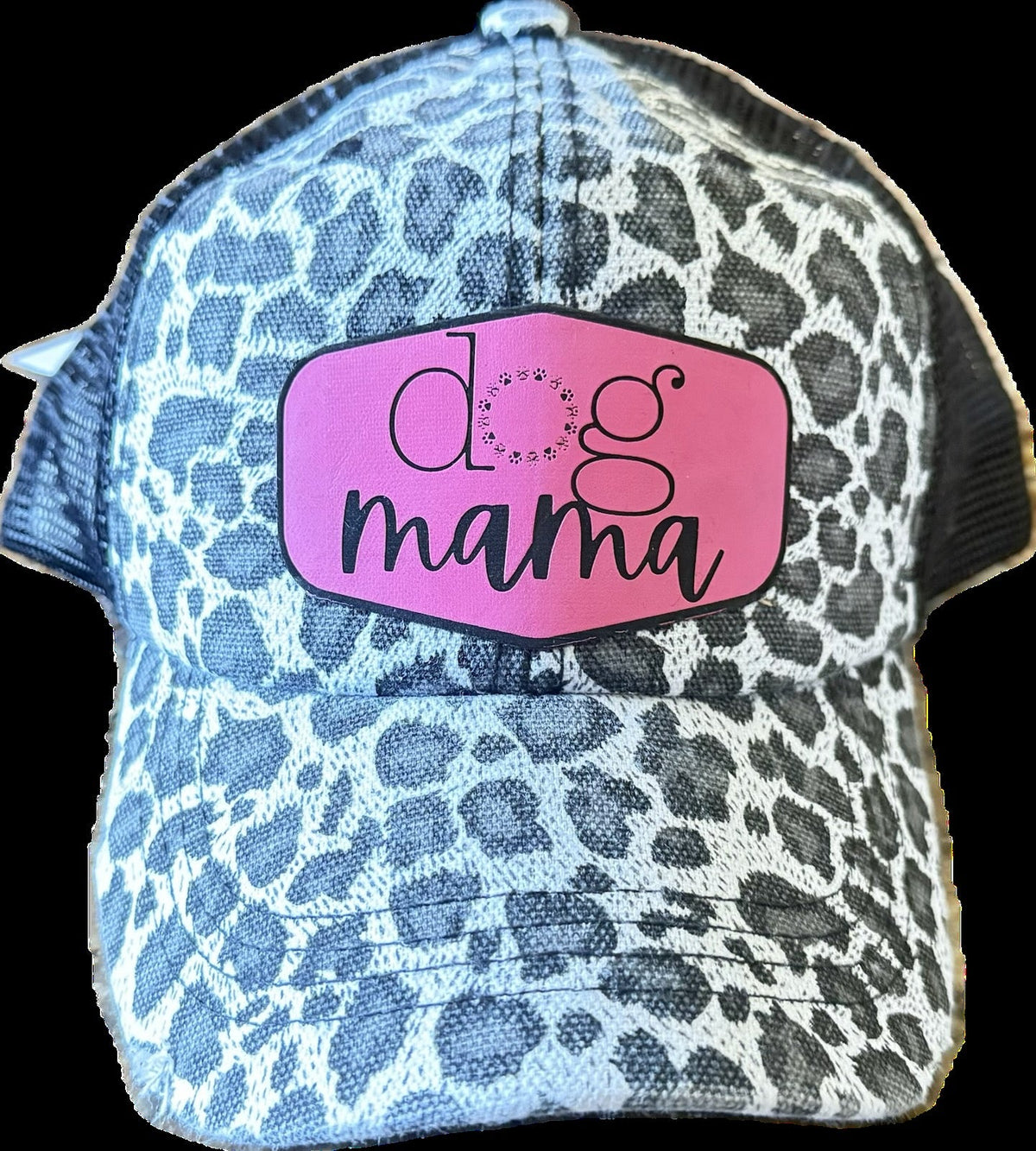 A trucker-style baseball cap with a blue and white leopard print pattern, featuring a pink patch on the front with the text 'dog mama' in black script.