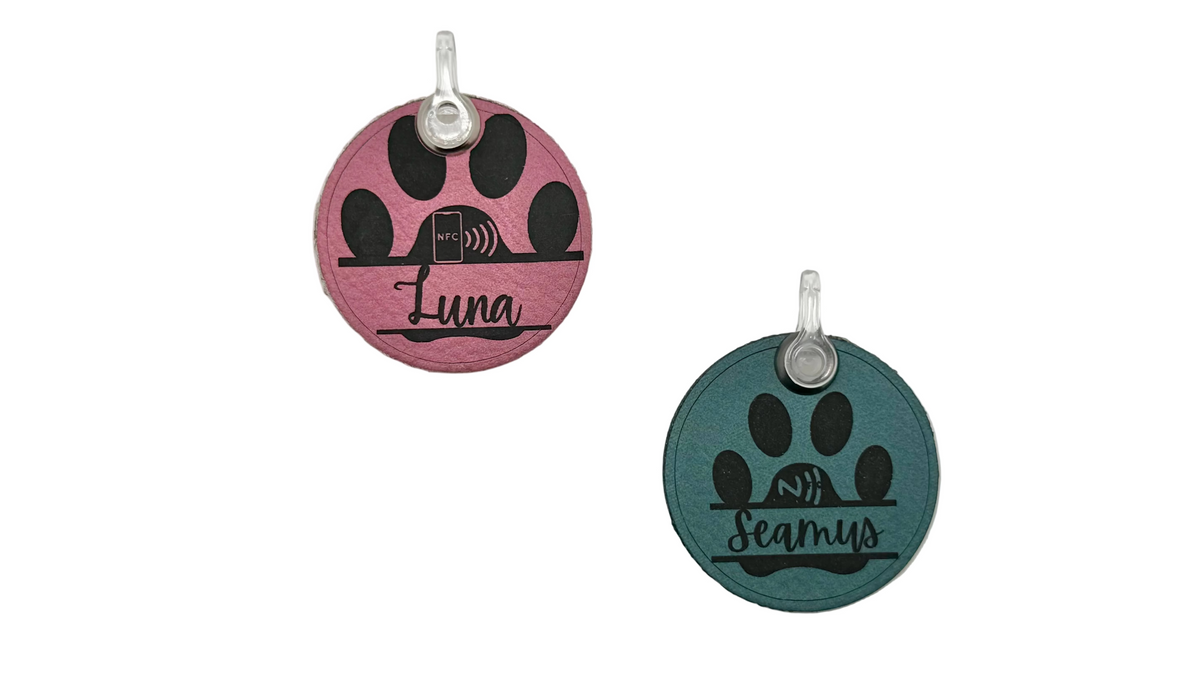Two round retractable dog leash collars on a light gray background, one in pink with black paw prints and the name 'Luna', and one in teal with black paw prints and the name 'Beverly'.