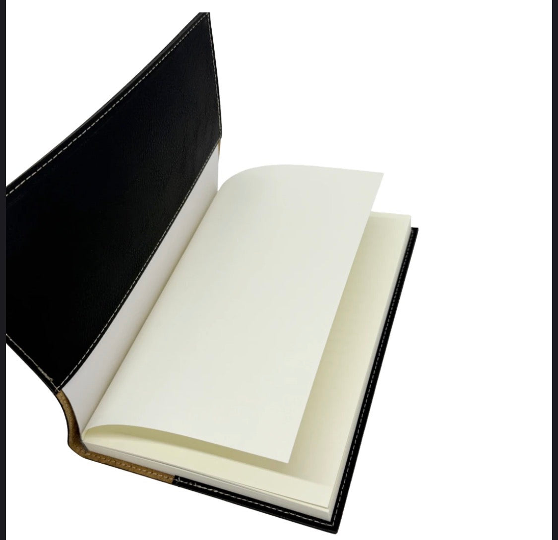 An open black leather-bound notebook or journal with blank off-white pages, shown against a plain white background.
