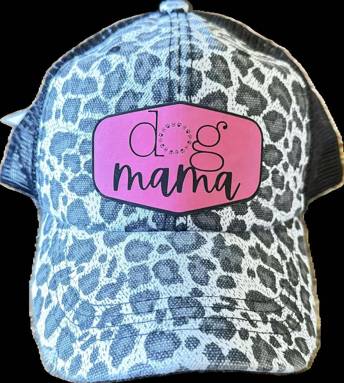 A trucker-style baseball cap with a blue and white leopard print pattern, featuring a pink patch on the front with the text 'dog mama' in black script.