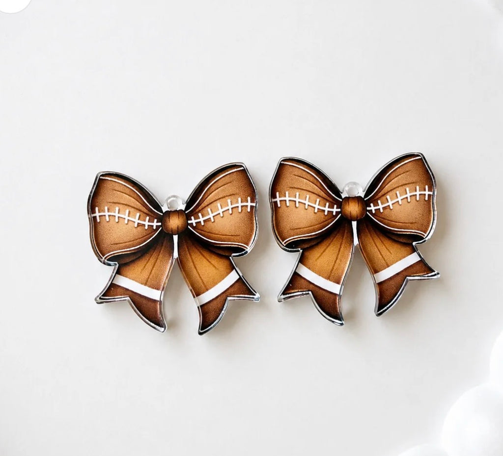 "Football-textured acrylic bow earrings with white laces detail, perfect for game day outfits"
