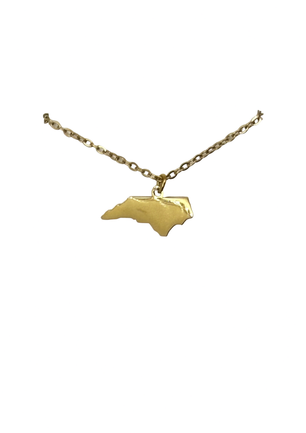A gold necklace with a pendant shaped like the state of North Carolina, displayed on a white card hanger against a white background.