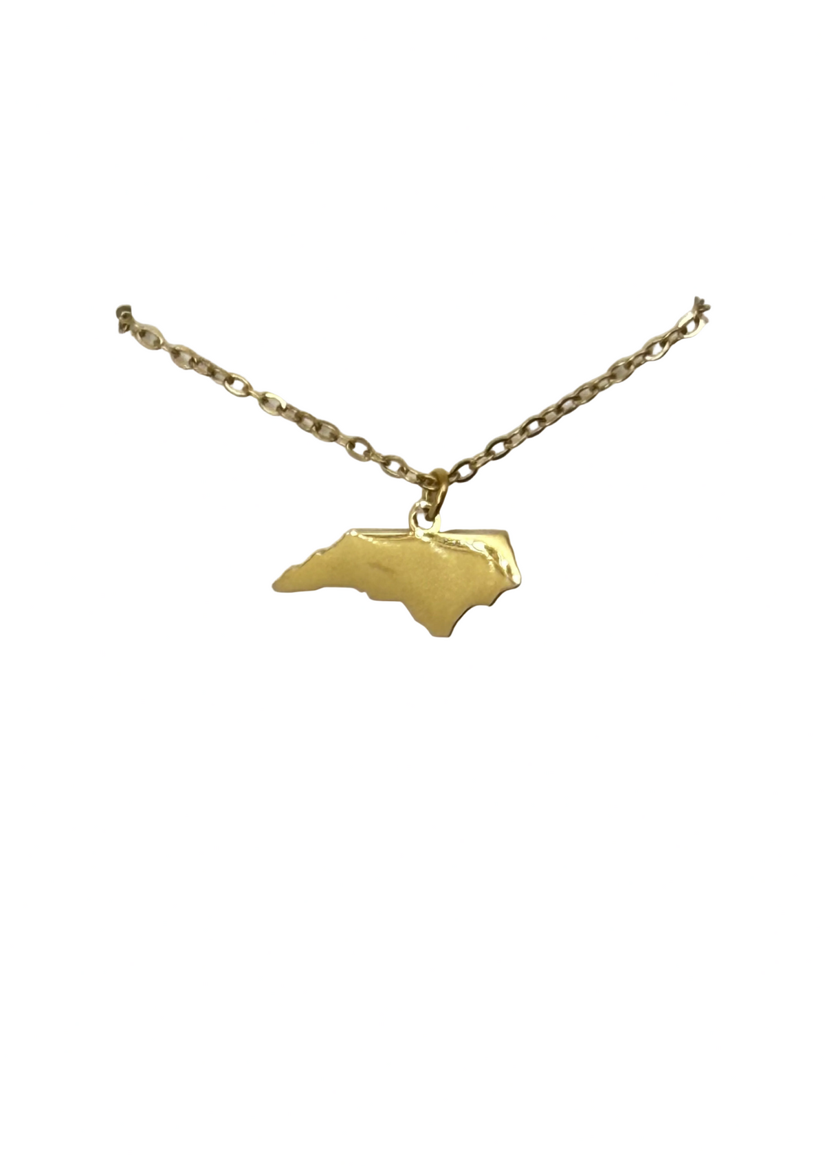 A gold necklace with a pendant shaped like the state of North Carolina, displayed on a white card hanger against a white background.