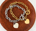 "Chunky chain link bracelet with polished heart tag charm and toggle clasp in gold-tone and silver-tone stainless steel"
