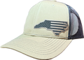 A beige trucker cap with a dark mesh back and a gray embroidered patch of the state of North Carolina filled with a distressed American flag design.
