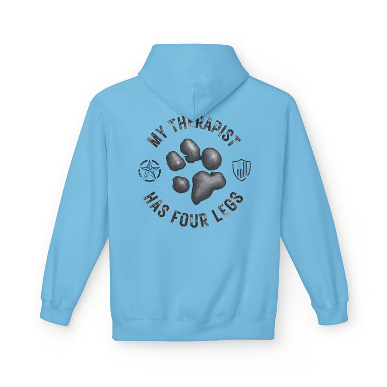 A light blue hoodie shown from the back, featuring a dark gray graphic print with a paw print, the text 'MY THERAPIST HAS FOUR LEGS', and small shield-like icons on a white background.