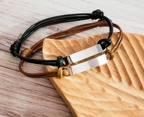 "Adjustable woven cord bracelet in brown and black with mirror-polished engravable stainless steel bar"
